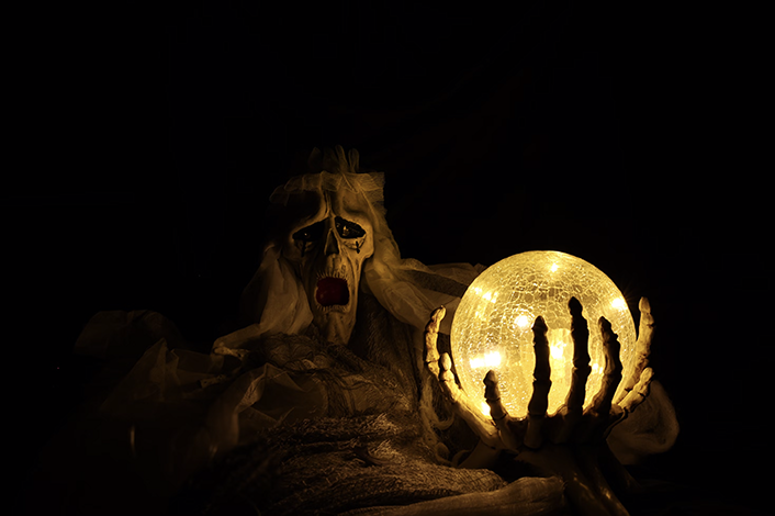 creepy skeleton in the dark holding a glowing crystal ball 
