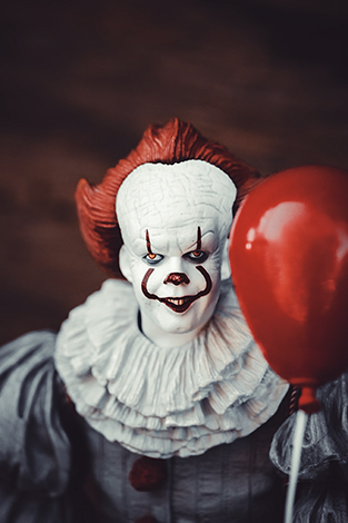 the clown from IT holding a red balloon